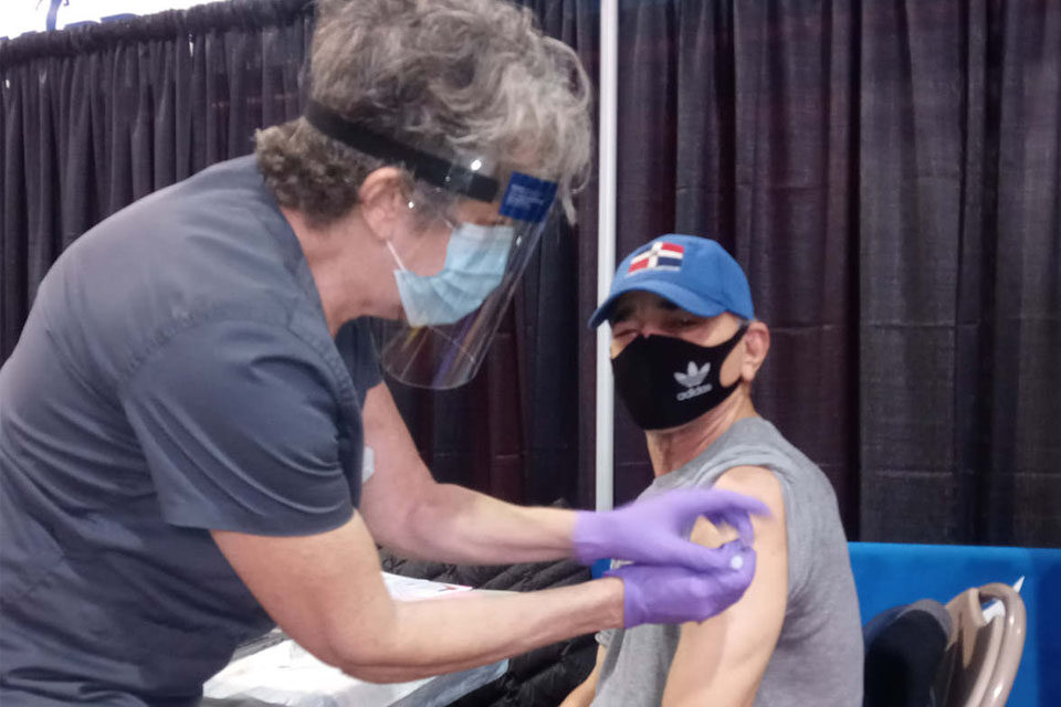 Reportero Cruz Tejada recibe primera vacuna de Moderna contra COVID – 19 y explica proceso
